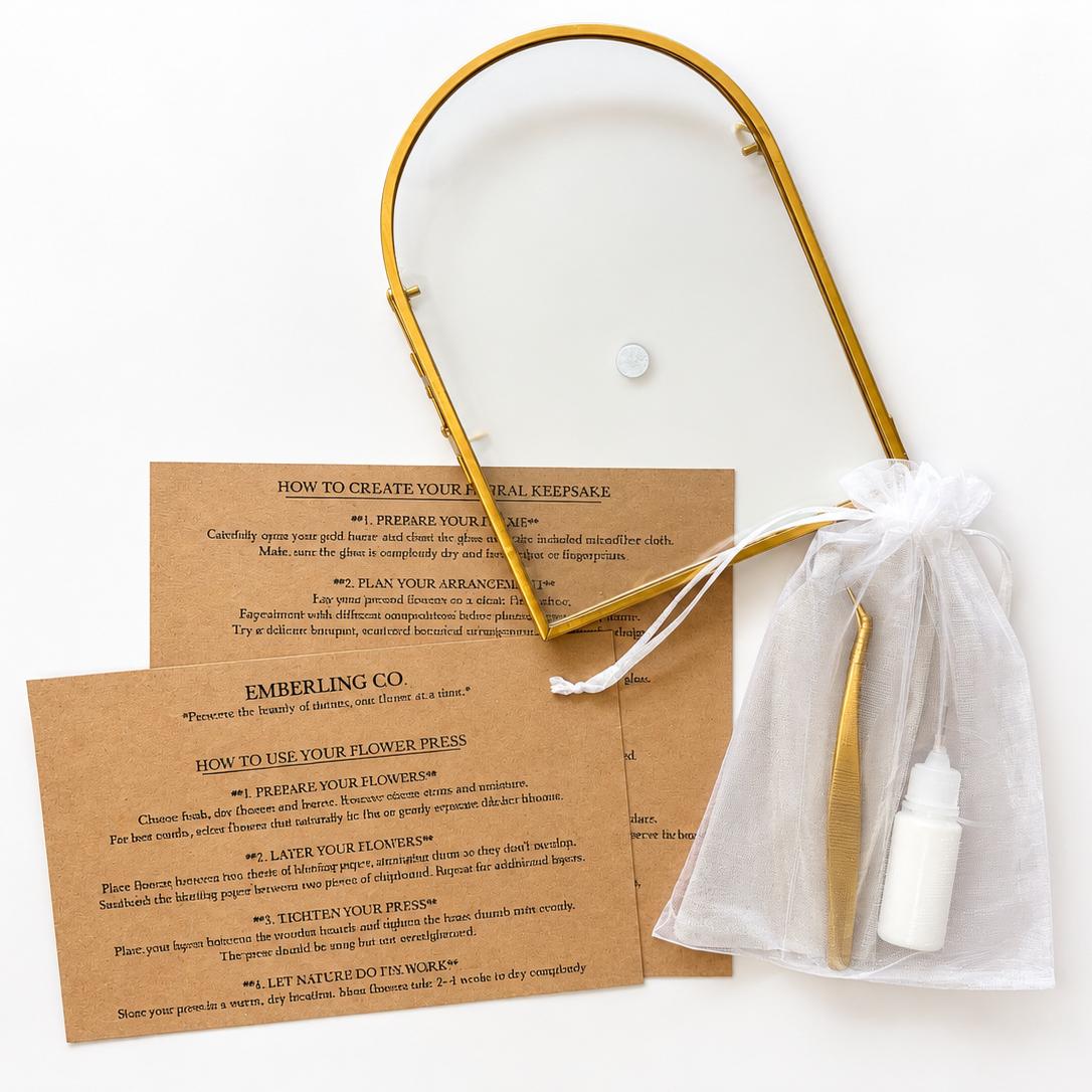 A gold metal arched frame with a white sheer drawstring pouch containing a white spray bottle, displayed over two printed cards with text about flower care on a white background.