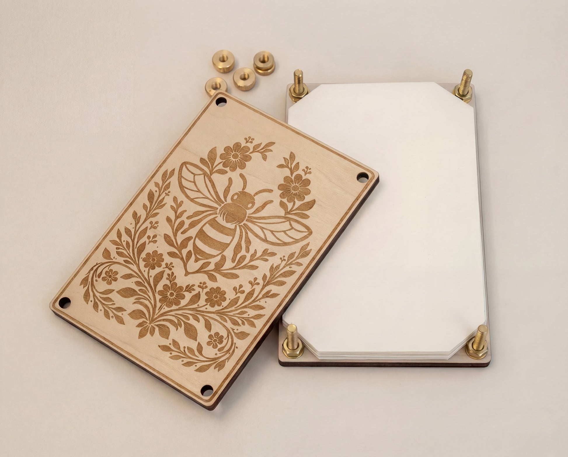 Bee engraved 4x6 wooden flower press kit shown disassembled, featuring a 5.2mm premium maple MDF core board top plate with botanical floral engraving, matching back plate, and brass hardware components (bolts and knurled thumb nuts) laid out to show how the pressed flower kit assembles for pressing and preserving flowers and leaves.