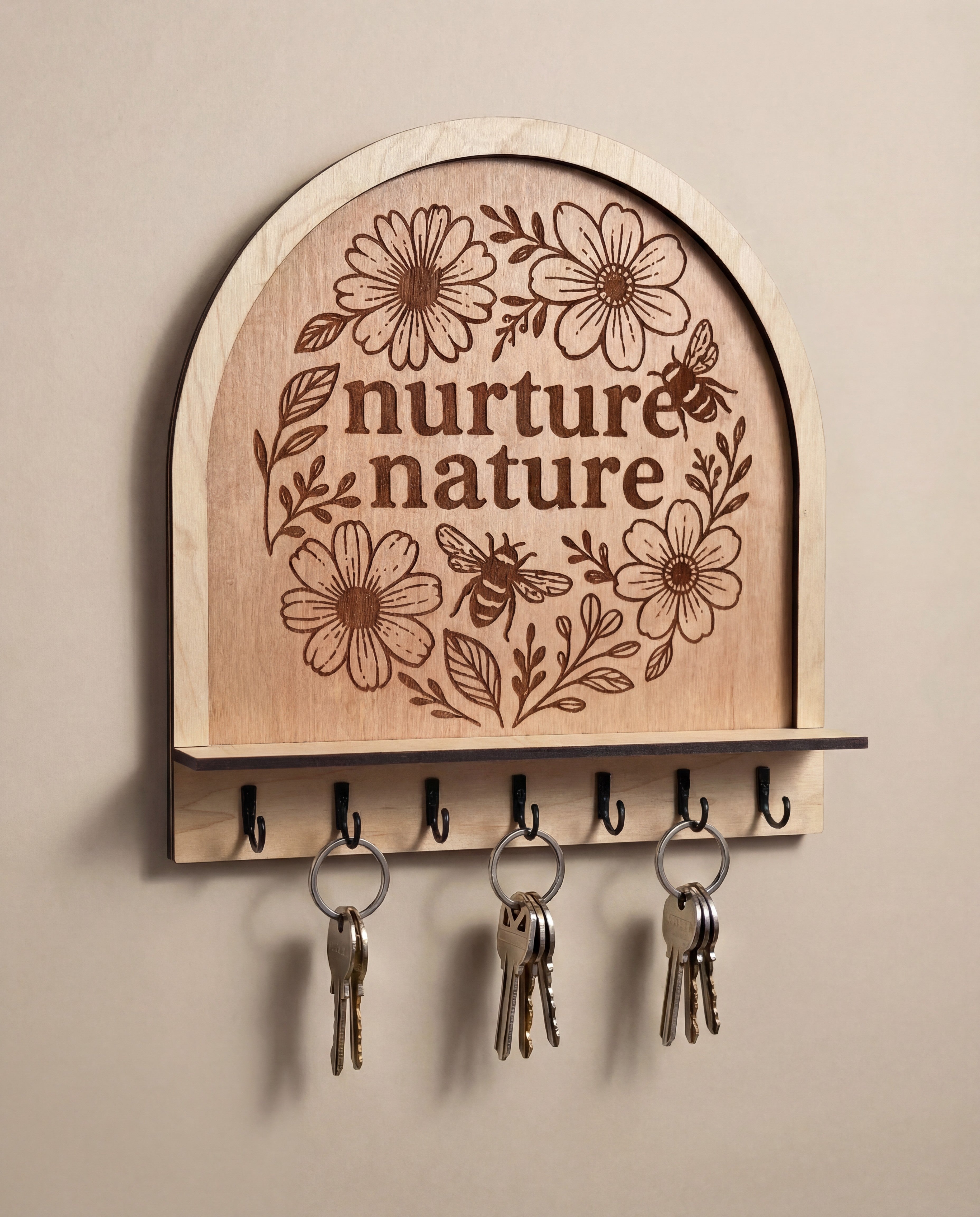 Arched wooden wall hook rack with “nurture nature” floral bee engraving and black metal hooks
